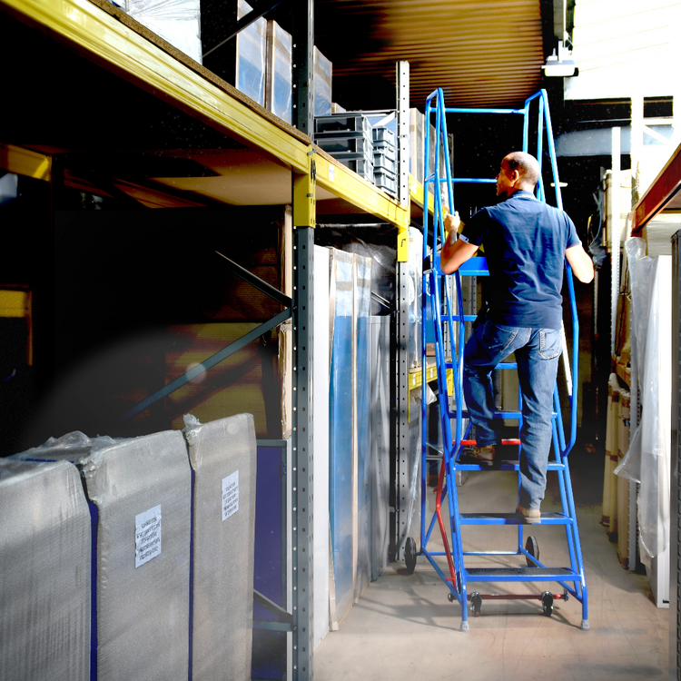 Man climbing a Ladders-Online warehouse step to pick an item from a shelf